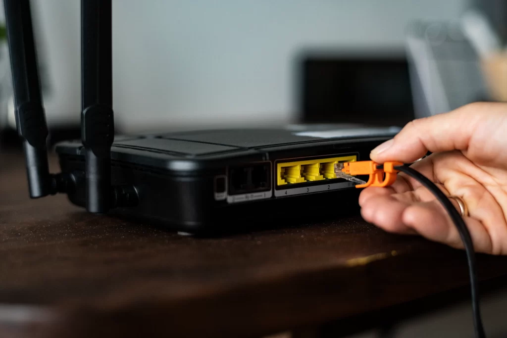man plugging ethernet cable wireless router